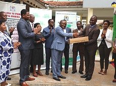 Katibu Mkuu Wizara ya Kilimo, Bw. Gerald Kusaya akimkabidhi Kompyuta Mrajis na Mtendaji Mkuu wa Tume ya Maendeleo ya Ushirika, Dkt. Benson Ndiege